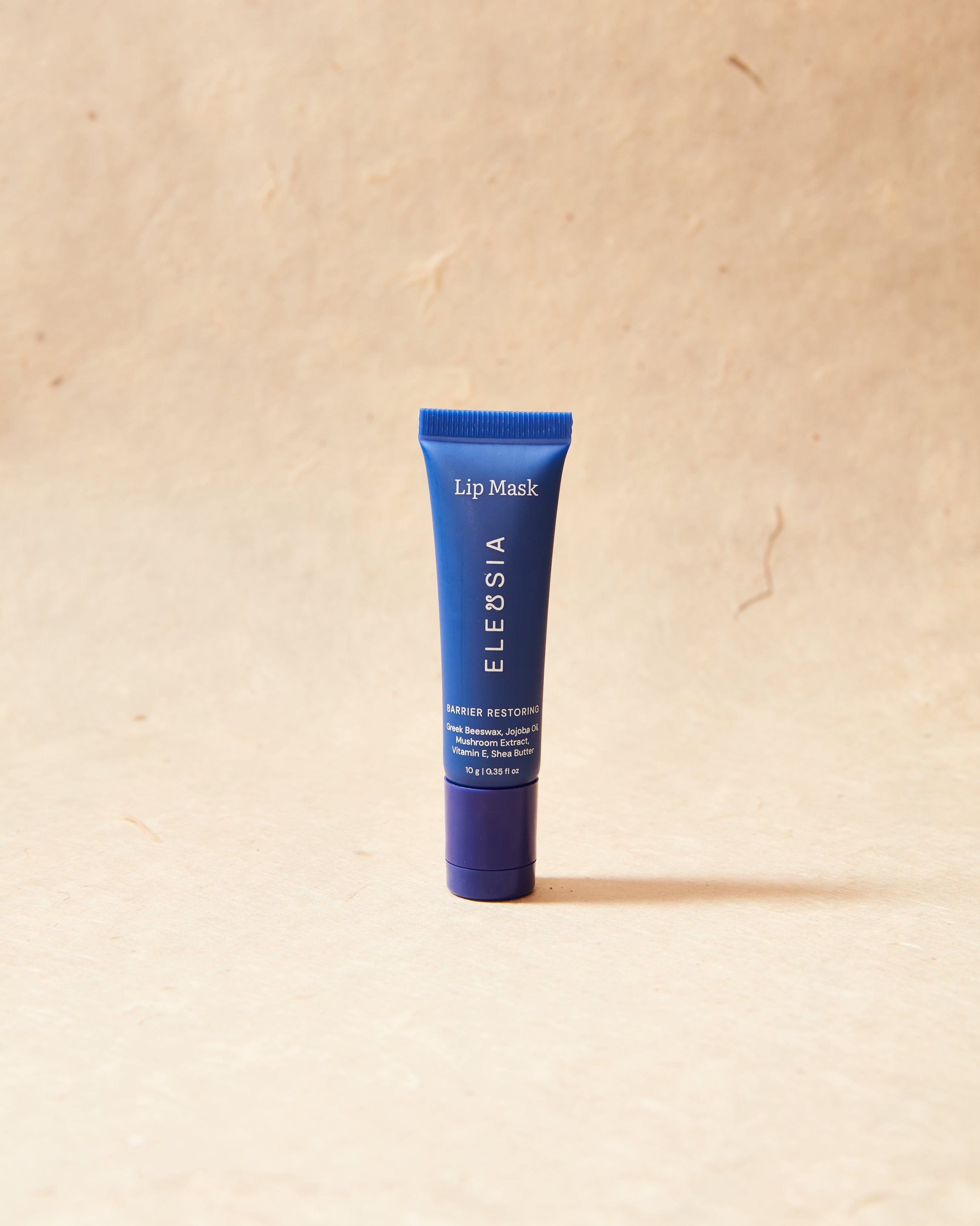 Blue lip mask tube on a beige background