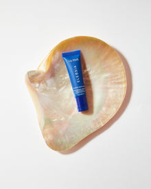 Lip mask tube on a decorative shell with a white background