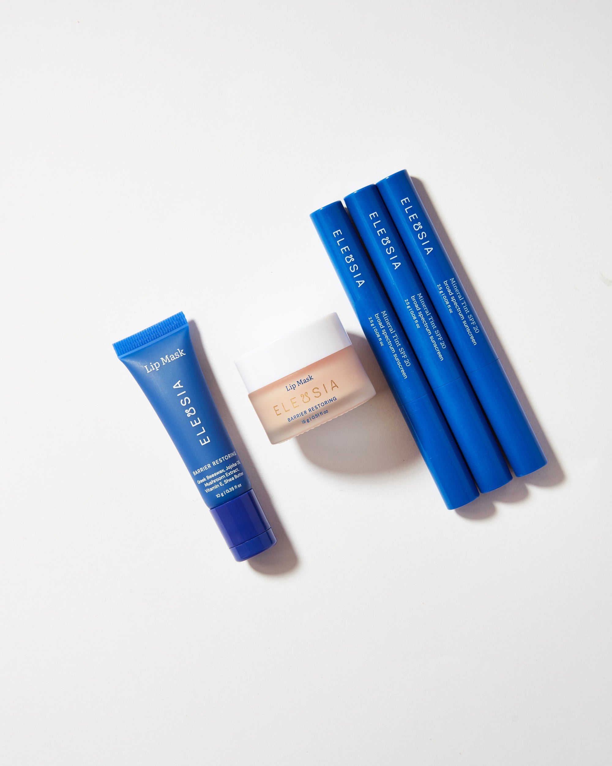 Blue lip mask packaging with a smaller beige product on a white background
