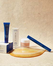 Elessia skincare products including a lip mask, cream, and applicator on a beige background