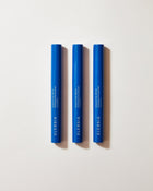 Three blue cosmetic tubes with 'Eleusia' branding on a light gray background
